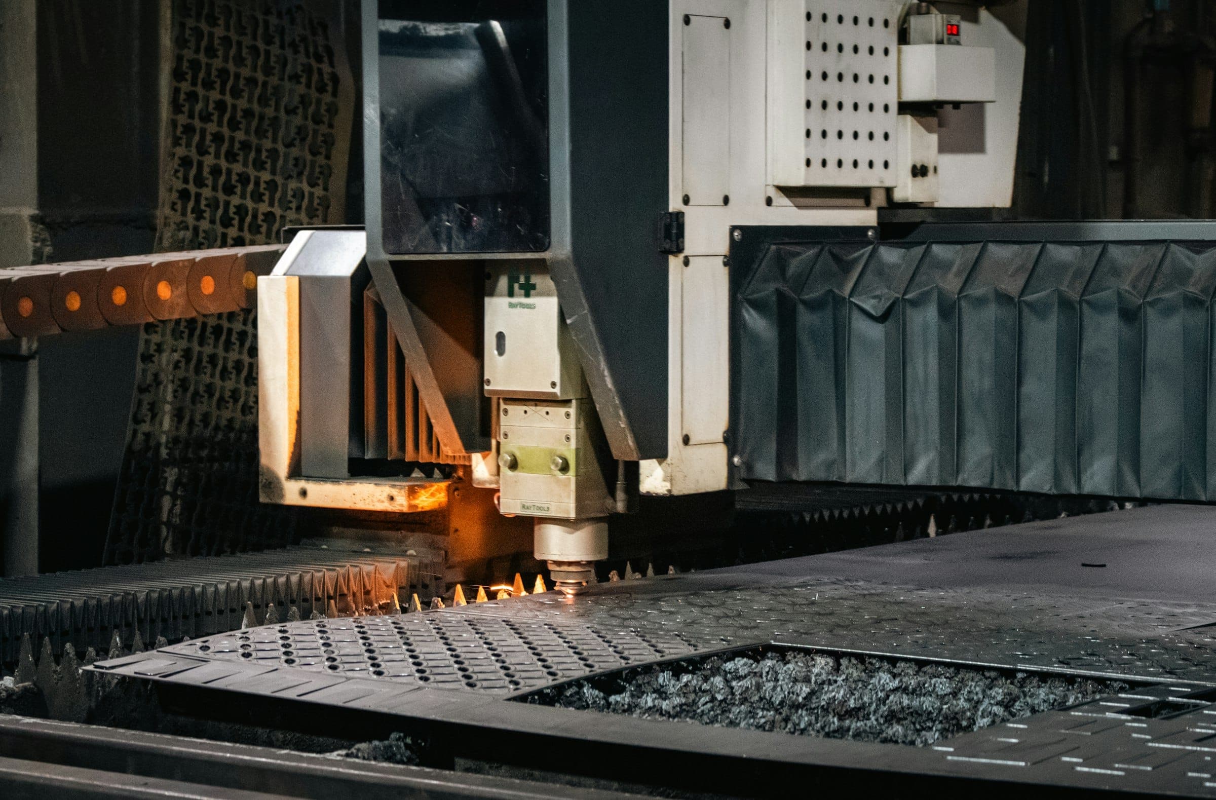 A laser cutter working a sheet of metal