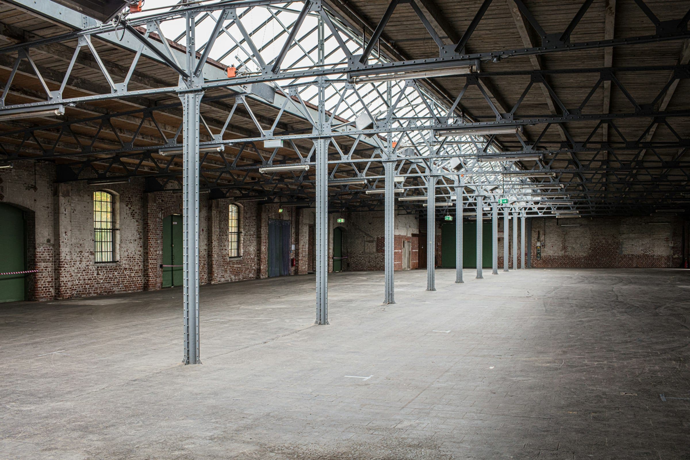 A long industrial hall with separate doors along one wall