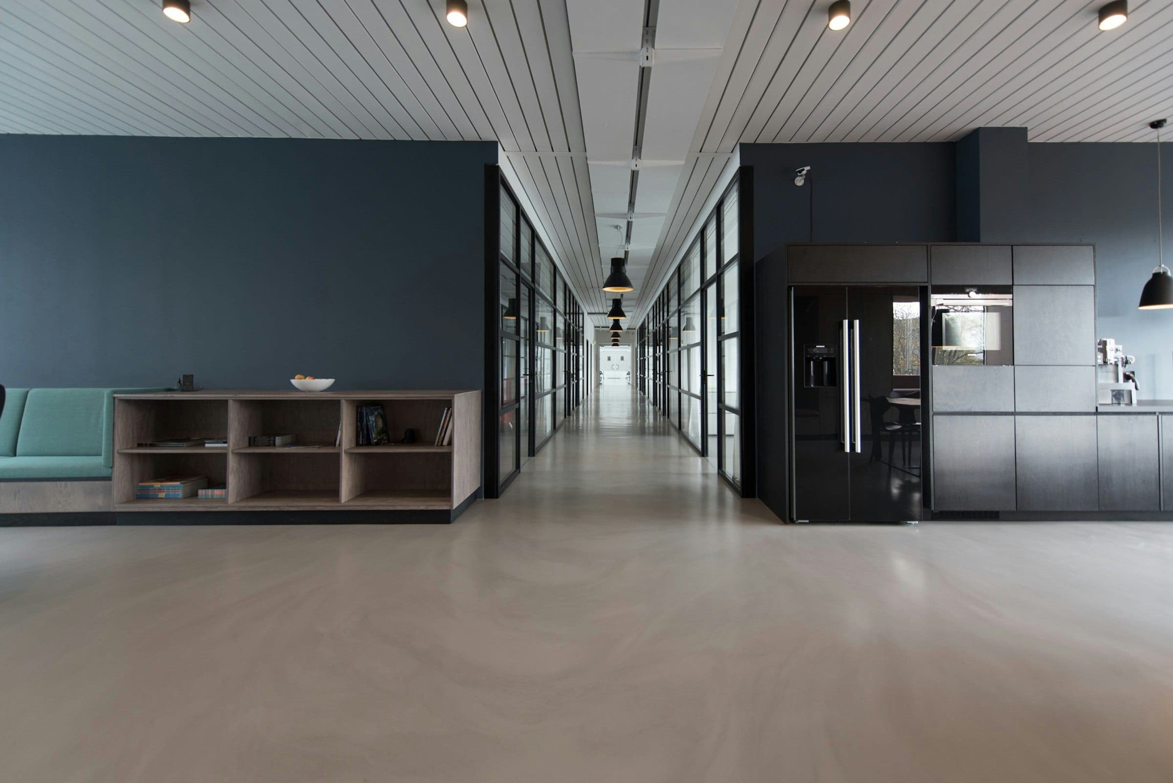 A quiet office corridor with glass meeting rooms
