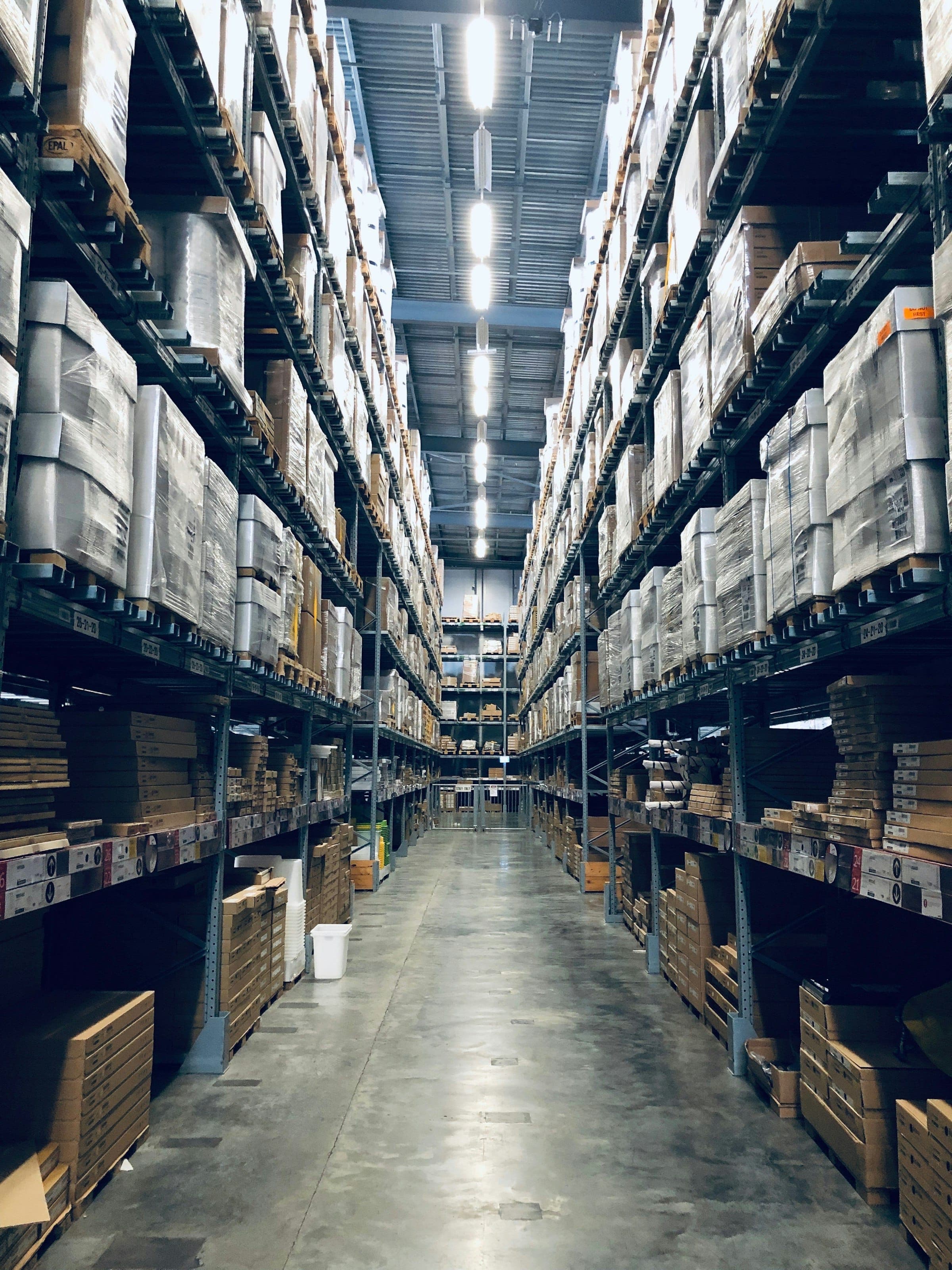 A warehouse aisle lined with stocked shelves
